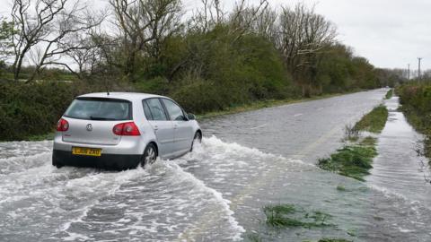 Car drives through flood water in Littlehampton, West Sussex
