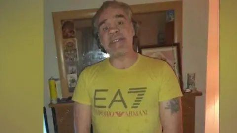 Family  Man with light hair and beard posing for camera wearing a yellow t-shirt 