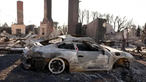 A burned car and building in Los Angeles