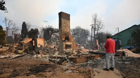 Getty Images A home is turned into a chimney after being destroyed by the Eaton fire in Altadena. 