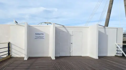 Big white hoarding at entrance to Southport pier