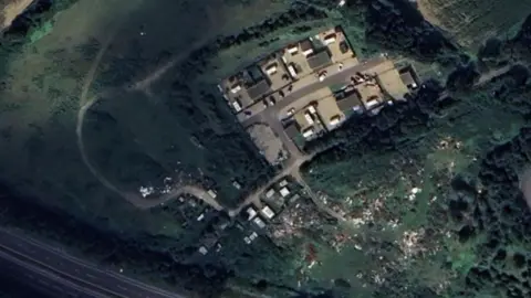 Google/LDRS Aerial view of fly-tipped rubbish in a field next to a caravan site and a recycling plant. The area is surrounded by fields.