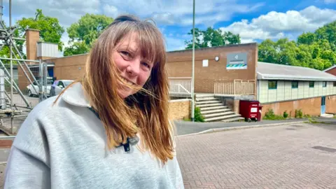 Colleen Natola wearing a grey zipped top outside the Northbrook swimming pool in Exeter