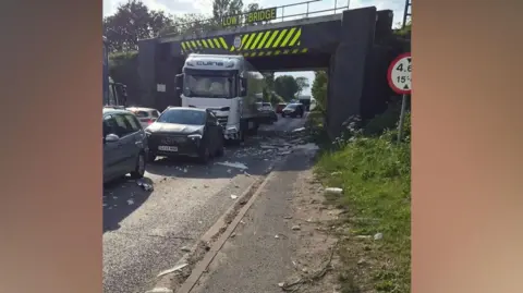 Supplied A lorry under a bridge with debris on the floor