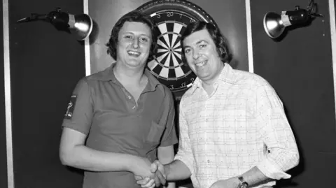 Getty Images A black and white picture of darts legends Eric Bristow and John Lowe
