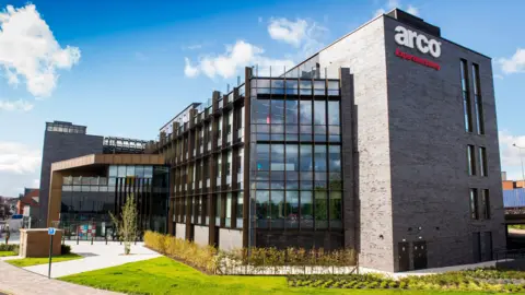 Arco Arco's Blackfriargate building. It is a large modern-looking building. The sky is blue.