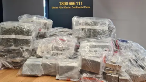 Garda National Drugs & Organised Crime Bureau Multiple plastic bags on a table filled with the seized drugs.