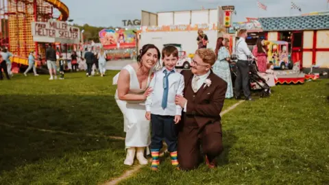 That Wild Eye Photography Faye and Adam Chandler with their son Billy after they got married and celebrated at a fairground. 