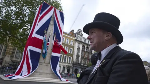 Getty An image of the Cenotaph in London during VE Day 80 celebrations. A man with a top hat stands to the right side. 
