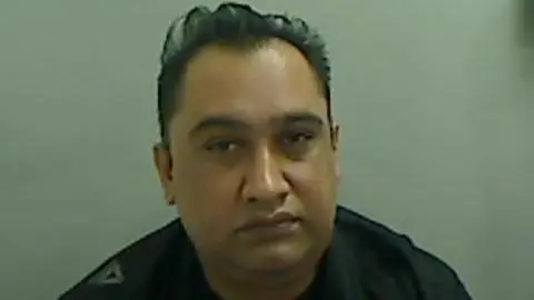 Mugshot of Chaudrhy. He is clean-shaven and has short black hair.