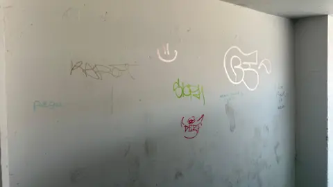 Graffiti tags on an off-white wall