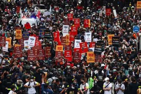 Getty Images Para pengunjuk rasa mengambil bagian dalam demonstrasi di Bangkok pada 14 November 2021, setelah pengadilan Thailand memutuskan bahwa pidato para pemimpin protes yang menyerukan reformasi kerajaan merupakan upaya untuk menggulingkan monarki negara tersebut. 