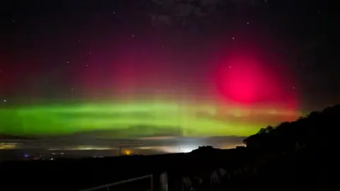 Skywatcher/BBC Weather Watchers Beams of green and pink light illuminate Haddington in East Lothian, Scotland.