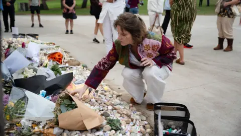 A woman lays flowers at the scene of the Bondi beach shootings