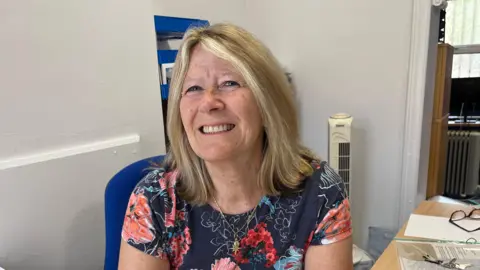 Suzanne King smiles from her desk at TaxAssist Accountants in Sutton-at-Hone