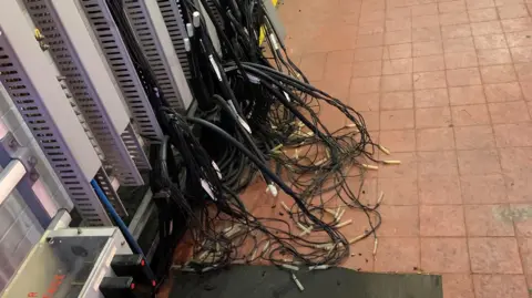 National Rail  Signalling equipment at Northampton. The wires look to have been pulled away from the wall and are on the floor or the same building the engineers were in in the above image. 