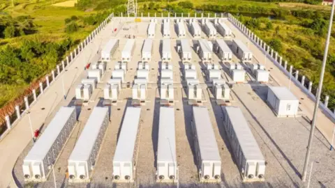 An image of a battery energy storage facility in the middle of open countryside. 