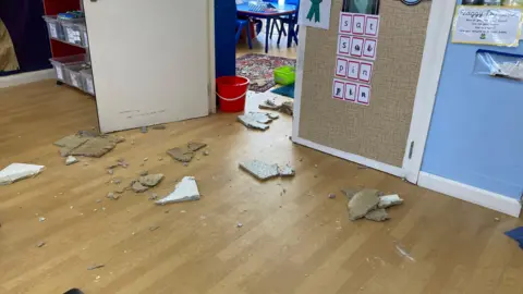 Broken pieces of tile on a wooden floor in a school