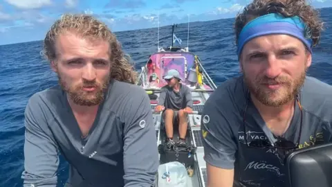 Three brothers on a rowing boat in the Pacific Ocean