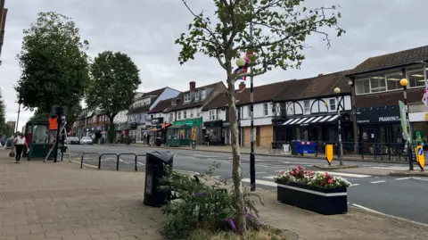 Matt Knight/BBC A general view of Epping High Road, with its long line of independent shops and cafés. This picture has been taken on a grey, cloudy day.