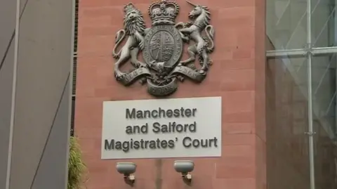 Close up image of a sign outside the entrance to Manchester and Salford Magistrates' Court