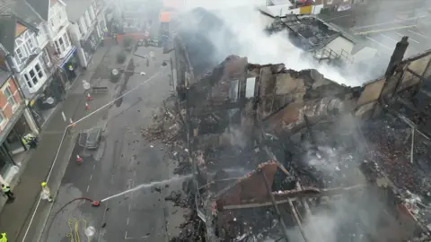 Birdseye view of the destroyed buildings and fire crews battling the blaze