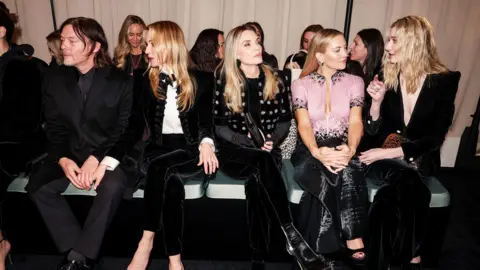 Getty Images Norman Reedus, Diane Kruger, Michelle Pfeiffer, Kate Hudson and Elizabeth Debicki sit side-by-side - Hudson and Debicki are talking, while the others look off to the side. All are wearing black or black-and-white outfits, while Hudson wears a pale pink embellished top 