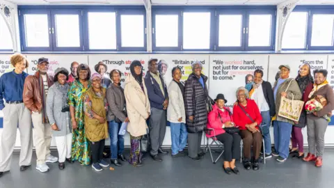 David Garcia A line up of people in front of portraits 