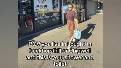 Georgia Harrison/BBC Georgia Harrison's post on her Instagram story. It reads: "POV you live in Loughton, Buckhurst Hill or Chigwell and this is your shower and toilet." She is walking down a street carrying multipacks of water.