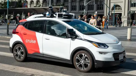 Getty Images A General Motors Cruise self-driving car, often referred to as a robotaxi, drives in front of the Ferry Building on the Embarcedero, San Francisco, California, 17 August, 2023.