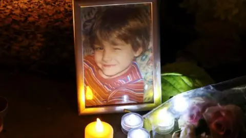 Reuters Des bougies sont placées devant une photo du jeune ancien chanteur des One Direction Liam Payne, tandis que les gens déposent des hommages et des fleurs devant la collégiale Saint-Pierre en mémoire de lui, à Wolverhampton, en Grande-Bretagne, le 18 octobre 2024.