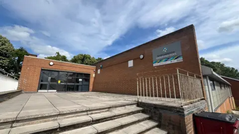 The Northbrook swimming pool building seen fro the outside, looking up the steps to the main entrance.