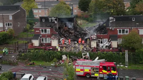 BBC Emergency services at the scene. An explosion has ripped through the middle house of a block of terrace houses.