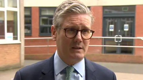 BBC Sir Keir Starmer in a dark blue suit and green patterned tie