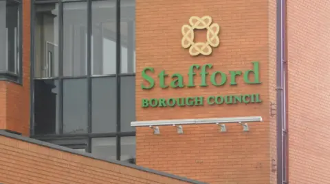 LDRS A red brick building, with black framed windows to the left and the words Stafford Borough Council in green to the right.