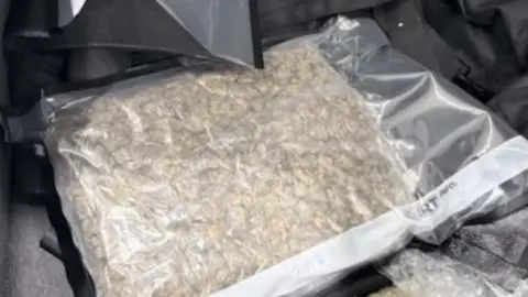 SWROCU This photo has a clear cellophane bag with a large amount of cannabis inside. The bag appears to be inside a box or cupboard.