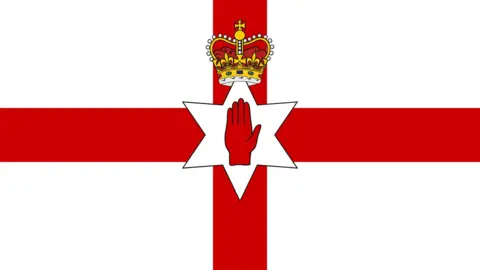 Getty Images The flag has a red cross on a white background. On top of the centre of the cross is a six-pointed white star. The top point of the star protrudes inside a golden crown with precious stones and inside the star is a red hand with the palm open.  