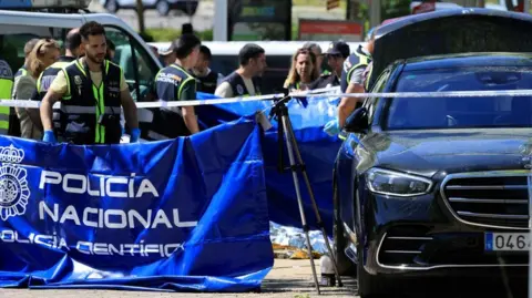 Reuters Police officers stand near the car of ex-Ukraine MP Andriy Portnov after he was shot dead outside a school in Madrid