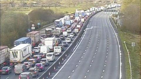 Cars queuing on the M25 with the anti-clockwise lanes empty