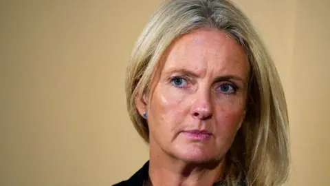 Head and shoulders crop of one of Mr Al Fayed's accusers, Natacha (no surname given) frowning and looking away from camera during a press conference relating to the claim against Harrods, in London on 20 September