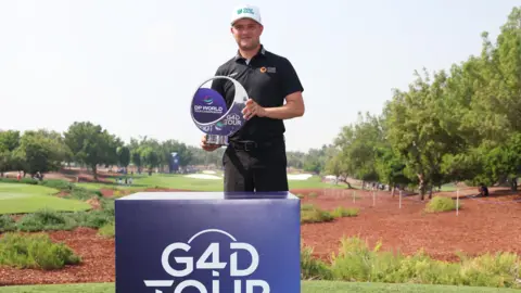 Getty Images Kipp Popert holding a trophy after winning the G4D Tour Series Finale in Saudi Arabia in 2024, a tour which has now been cancelled, leaving Kipp with doubts over his future and how he'll fund competition
