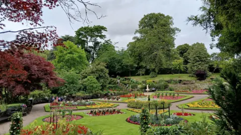 BBC Weather Watchers/Fredbear A wide shot of the Dingle formal gardens at the main park in Shrewsbury, the Quarry. Beds are laid out among trees, lawns and paths with flowers in a variety of colours