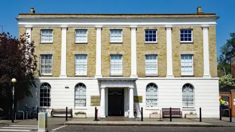 Jim Osley/Geograph The three-storey Witham Library building seen from the street. It is a grand building, with white panelling covering the lower third of the building and cream brick covering the remainder.