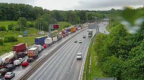 Queues of lorries and cars at a standstill on the northbound M6 while traffic moves freely on the soundbound carriageway opposite.