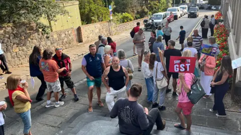 BBC A number of people with Say no to GST placards standing outside Guernsey's Royal Court.