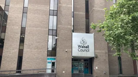 LDRS A large brick building with lots of glass panels and a sign reading "WalSALL council" with a tree to the right