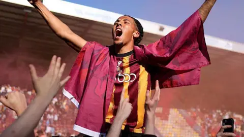 Romoney Crichlow celebrates with Bradford City fans after the Bantams earned promotion to League One