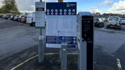 A parking meter in a car park