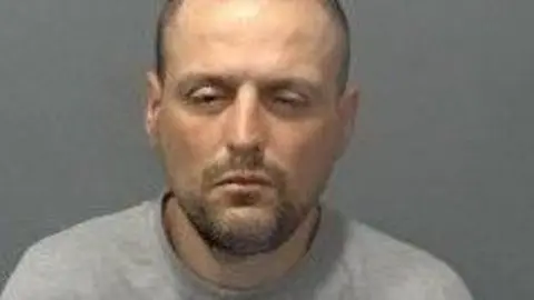A police mugshot of Peter Janoski wearing a grey top