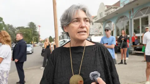 Woman standing on street corner being interviewed in Bondi Beach, Australia